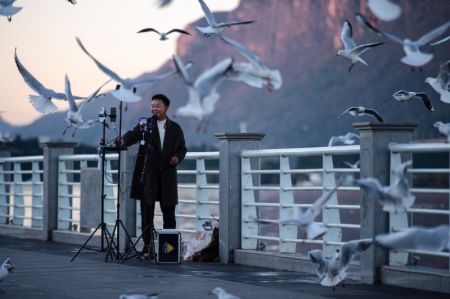(miniature) Un homme réalise une vidéo au bord du lac Dianchi à Kunming
