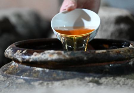 (miniature) Un villageois montre du vin jaune fait maison dans le village de Beiqian du bourg de Daixi