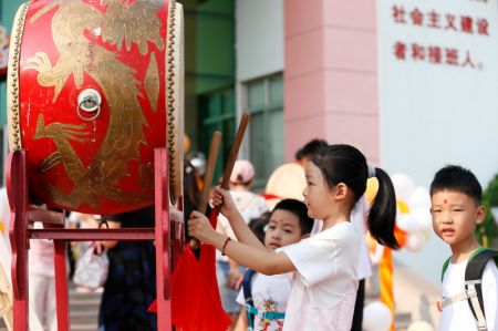 (miniature) Une élève bat le tambour dans une école primaire à Qingdao