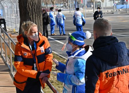 (miniature) Une bénévole parle aux habitants du village olympique pour les Jeux olympiques d'hiver de Beijing 2022 dans le centre-ville de Beijing