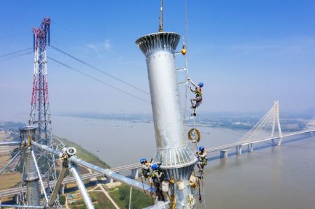(miniature) Des techniciens sur le chantier du projet de transmission d'&eacute;lectricit&eacute; &agrave; ultra-haute tension Baihetan-Zhejiang pr&egrave;s du fleuve Yangts&eacute;
