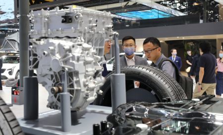 (miniature) Des visiteurs discutent en examinant une plate-forme de véhicules à énergies nouvelles de Cadillac lors de la 20e édition du Salon international de l'industrie automobile de Shanghai (Auto Shanghai)
