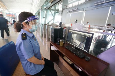 (miniature) Une employée surveille les températures corporelles des passagers sur un ordinateur à la gare de Nanjing