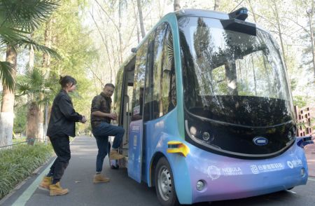 (miniature) Des touristes montent dans un bus touristique autonome dans le parc forestier national de Binhu