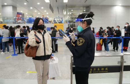 (miniature) Une membre du personnel de la douane de l'Aéroport international Pudong de Shanghai vérifie les informations d'une passagère en provenance de l'étranger