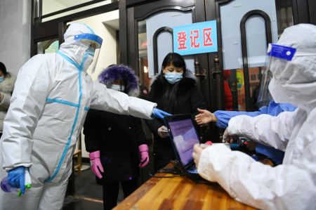 (miniature) Des travailleurs m&eacute;dicaux enregistrent les informations des habitants sur un site de d&eacute;pistage dans une &eacute;cole primaire de Harbin