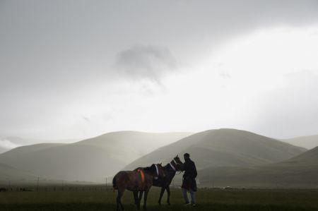 (miniature) Un cavalier et ses chevaux avant une course hippique dans les prairies du district de Baiyu de la préfecture autonome tibétaine de Garze