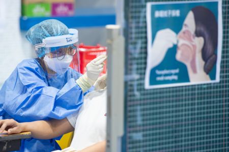 (miniature) Une professionnelle médicale effectue un prélèvement nasal sur un habitant pour le test d'acide nucléique à Macao
