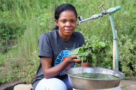 (miniature) Une femme lave des légumes avec de l'eau fournie par le nouveau projet d'approvisionnement en eau d'Arusha entrepris par Power Construction Corporation of China (PowerChina)
