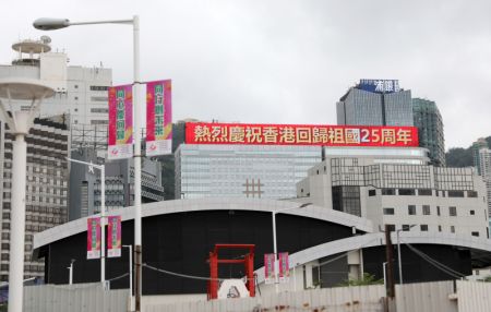 (miniature) Un slogan célébrant le 25e anniversaire du retour de Hong Kong à la patrie s'affiche sur un écran électronique sur la façade d'un bâtiment à Hong Kong