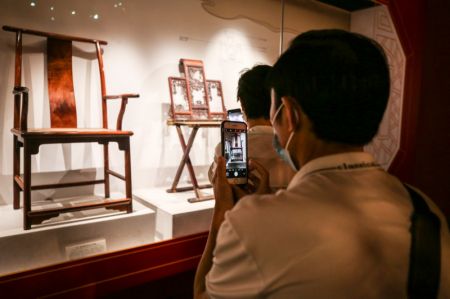 (miniature) Des gens visitent une exposition d'objets du Musée du palais