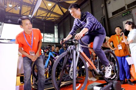 (miniature) Un visiteur s'essaie à un jeu de course à vélo lors de la 32e édition de la Foire internationale du vélo de Chine