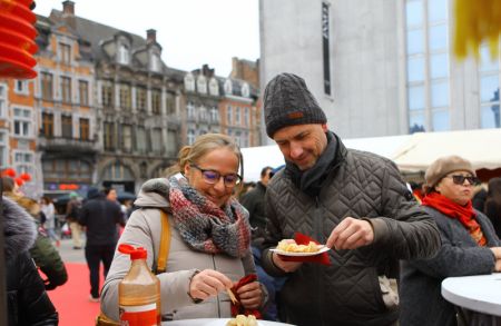 (miniature) Des gens dégustent des snacks chinois dans une foire célébrant le Nouvel An chinois à Namur (centre)