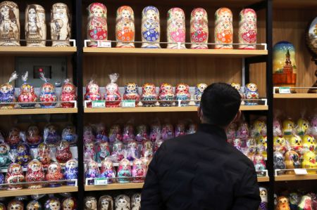 (miniature) Un client magasine des poupées matryoshka dans un magasin des produits russes à Manzhouli