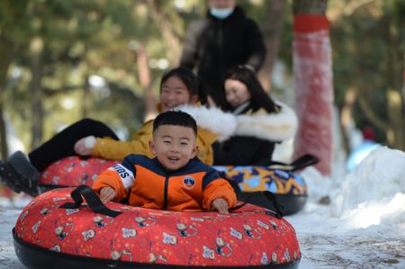 (miniature) Des enfants font de la bouée sur neige pendant les vacances du Nouvel An