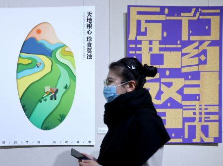 (miniature) Une visiteuse regarde des oeuvres primées lors d'une activité de conception d'intérêt public sur le thème de la promotion de la frugalité et de la réduction du gaspillage à Beijing