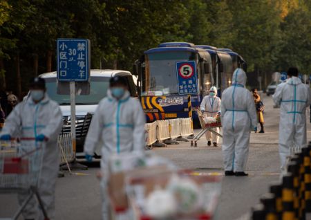 (miniature) Des membres du personnel distribuent des produits de premi&egrave;re n&eacute;cessit&eacute; dans le quartier r&eacute;sidentiel de Hongfuyuan