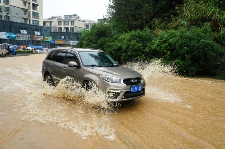 (miniature) Un véhicule circule sur une route inondée du district de Shexian