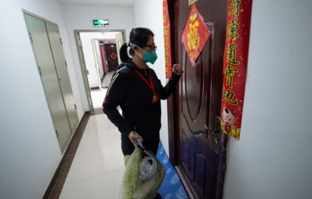 (miniature) Une travailleuse de quartier livre des l&eacute;gumes &agrave; une personne &acirc;g&eacute;e dans un quartier r&eacute;sidentiel de l'arrondissement de Haidian