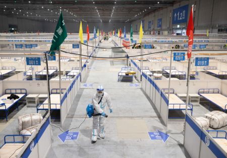 (miniature) Un membre du personnel désinfecte le chantier d'un hôpital temporaire au Centre national des expositions et des congrès (Shanghai)