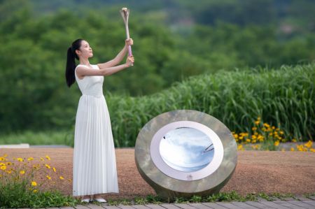 (miniature) Une femme présente la flamme lors de la cérémonie d'allumage de la flamme des Jeux asiatiques 2022 de Hangzhou