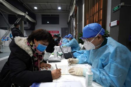 (miniature) Des membres du personnel aident des habitants à suivre les procédures et à renseigner leurs informations dans un centre de vaccination de l'arrondissement de Chaoyang