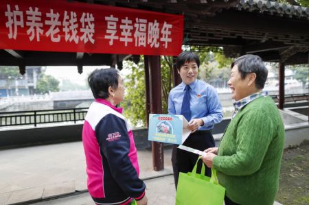 (miniature) Une policière partage des informations sur la prévention des fraudes par téléphone et Internet avec des personnes âgées dans un parc de la ville de Xinghua