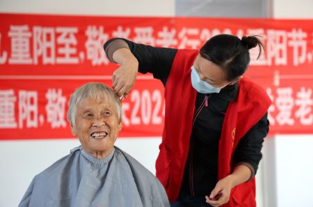 (miniature) Une bénévole coupe gratuitement les cheveux d'une femme âgée dans le village de Qintaigeng de la ville de Binzhou