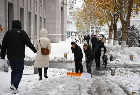 (miniature) Des personnes déblayent un trottoir après de fortes chutes de neige à Zhengzhou