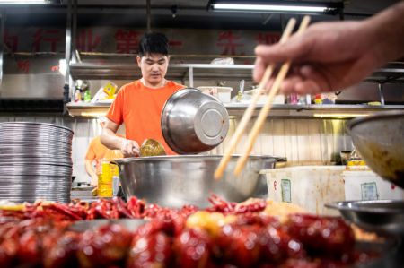 (miniature) Un cuisinier prépare des écrevisses dans un restaurant à Qianjiang