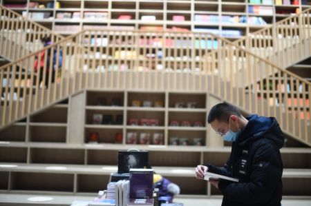 (miniature) Un homme lit dans une librairie à Xining