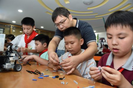 (miniature) Yang Sen donne des instructions à ses élèves au club de robotique de l'Ecole primaire Heping
