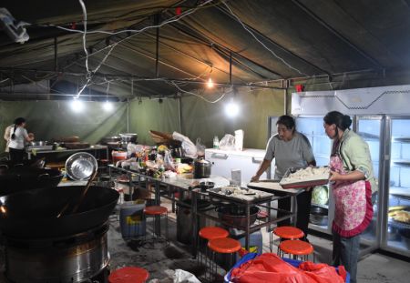 (miniature) Des gens cuisinent dans un site de relogement temporaire à Guzan