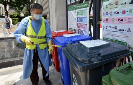 (miniature) Un travailleur communautaire désinfecte des poubelles d'une communauté résidentielle à Jiugong