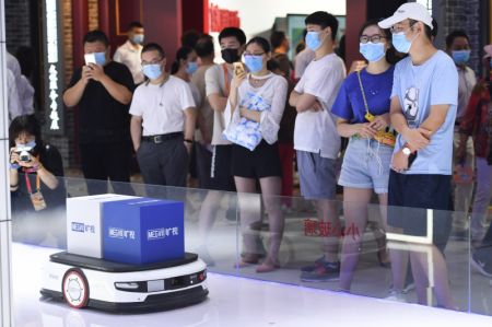 (miniature) Des gens observent un robot intelligent de logistiques dans le grand espace d'exposition du Salon international du commerce des services de Chine 2020