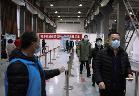 (miniature) Des habitants font la queue pour recevoir la deuxième dose du vaccin contre le COVID-19 dans un centre de vaccination de l'arrondissement de Chaoyang