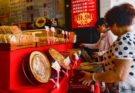 (miniature) Des consommateurs choisissent des gâteaux de lune dans un magasin de gâteaux de lune à la mode de Hainan