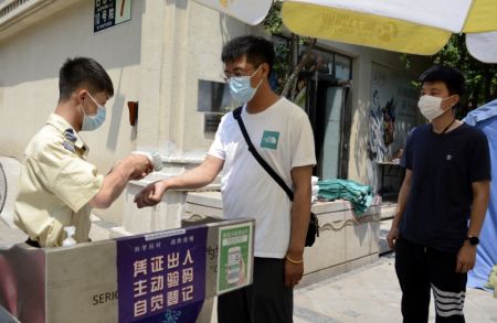 (miniature) Des habitants passent un contrôle de température avant d'entrer dans une communauté résidentielle à Jiugong