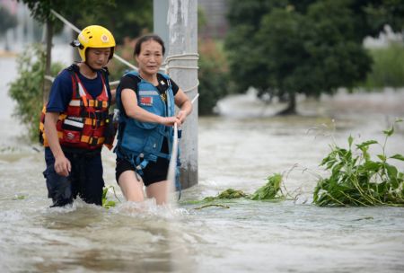 (miniature) Une femme traverse l'eau à l'aide d'un secouriste dans le bourg de Guzhen