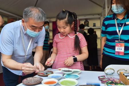 (miniature) Une fille apprend l'art du cloisonn&eacute; lors d'une animation &agrave; Beijing