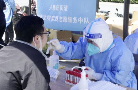 (miniature) Un professionnel de santé prélève un échantillon sur écouvillon sur un habitant pour des tests d'acide nucléique dans l'arrondissement de Chaoyang