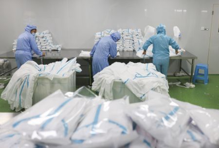 (miniature) Des travailleurs emballent des combinaisons de protection dans une usine du district de Fengdu de Chongqing