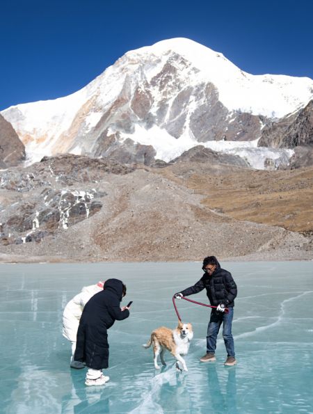 (miniature) Des touristes sur un lac glacé devant le mont Qungmknag