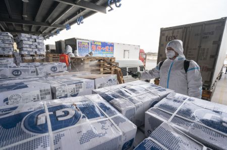 (miniature) Un employé pulvérise du désinfectant sur l'emballage des aliments importés de la chaîne du froid dans un centre régional de la chaîne du froid à Wuhan