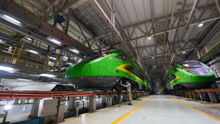 (miniature) Un technicien inspecte un train à grande vitesse dans un centre de maintenance d'Urumqi