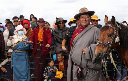 (miniature) Un cavalier se prépare à participer à une course de chevaux sur la prairie de Zhaqingtang lors du festival culturel nomade Jinma dans le district de Sertar de la préfecture autonome tibétaine de Garze