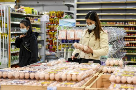 (miniature) Une habitante achète des oeufs sur un marché à Dongxing