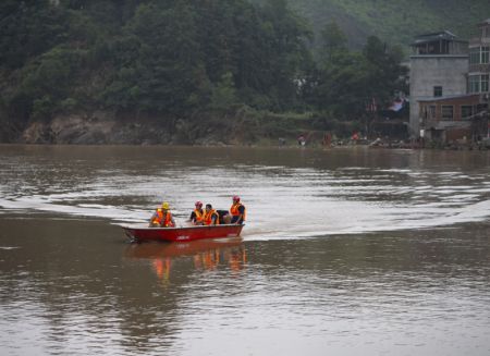 (miniature) Des secouristes aident des gens à transporter des fournitures dans le bourg de Xiangshuitan