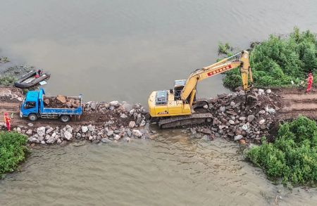 (miniature) Des secouristes tentent de colmater une brèche dans une digue à Tieling