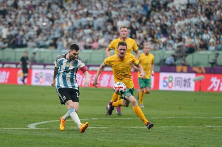 (miniature) La star argentine Lionel Messi (à gauche) aux prises avec l'Australien Kye Rowles lors d'un match amical entre l'Argentine et l'Australie à Beijing